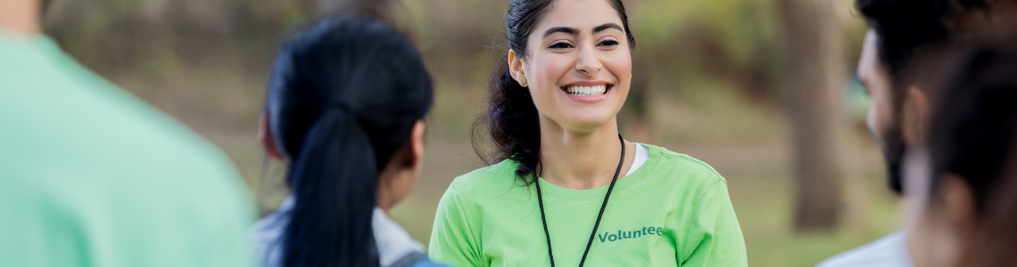 A female volunteer smiling to a group of people